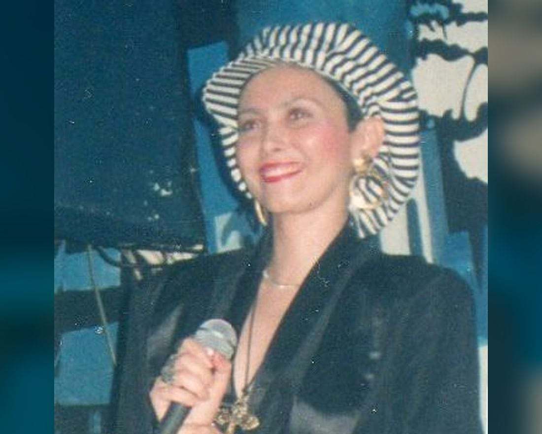 Christine Rabassa au micro, coiffée d’un chapeau rayé